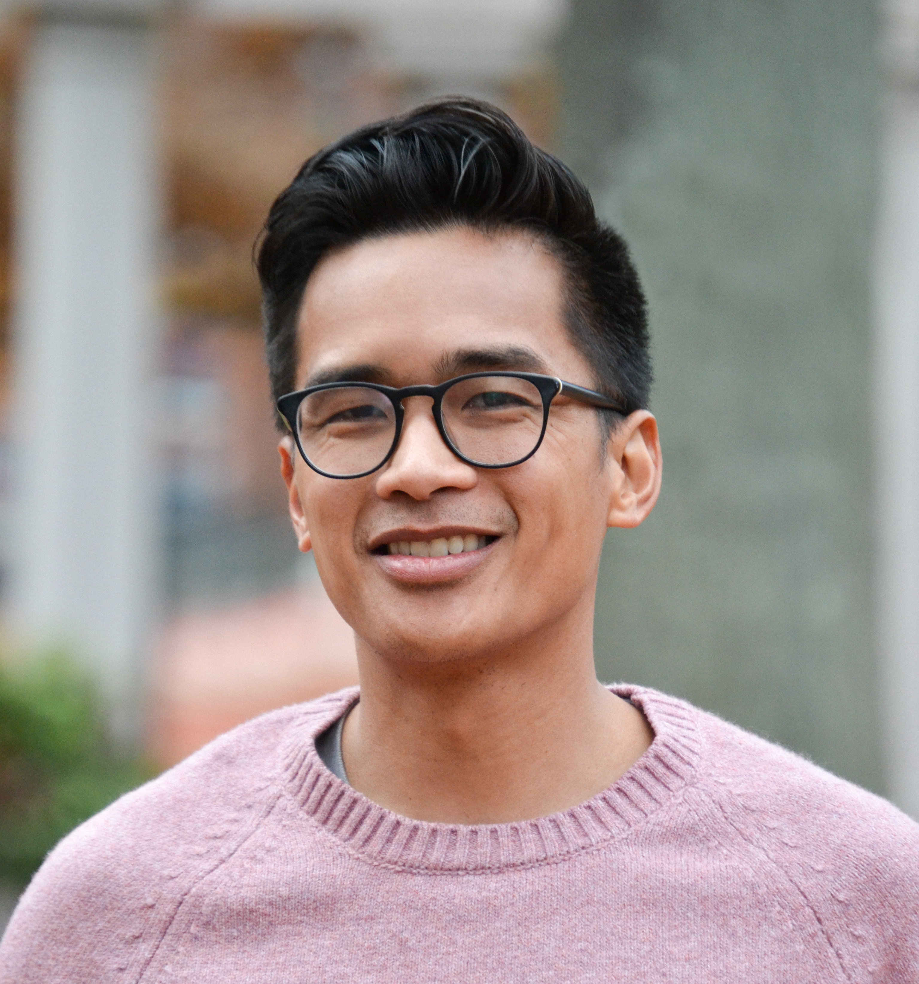 John Guigayoma stands wearing a pink shirt